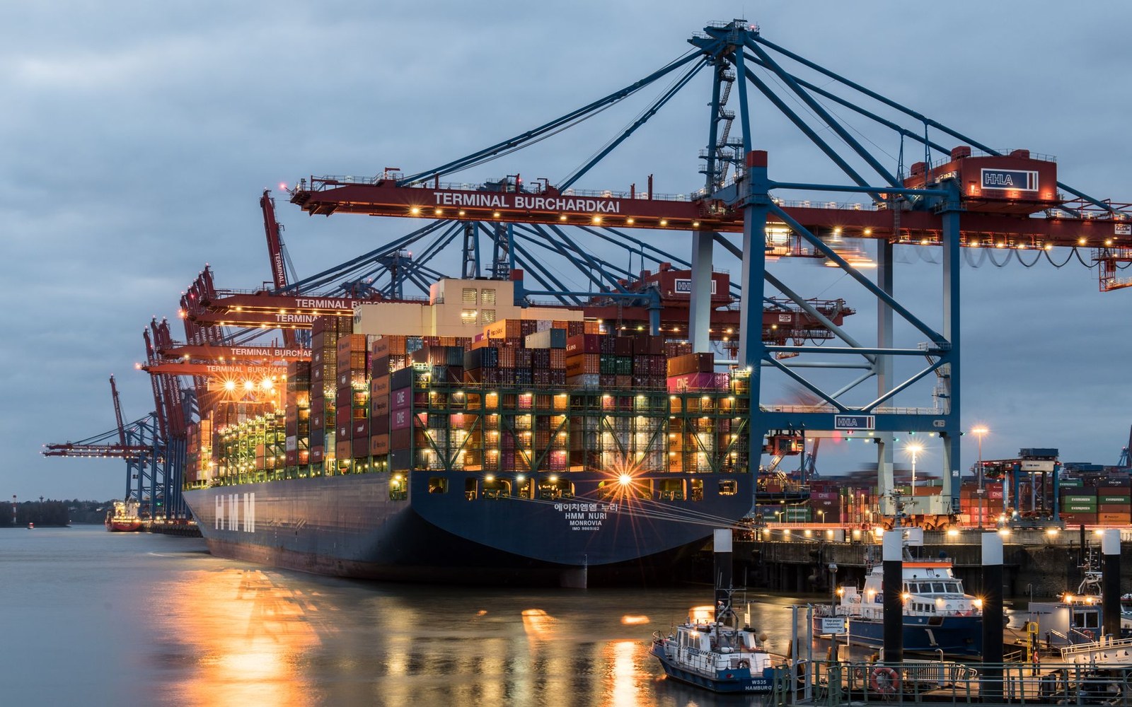 Navires porte-conteneurs à quai dans un terminal portuaire, avant le chargement d'une expédition de mobilier vers l'Europe