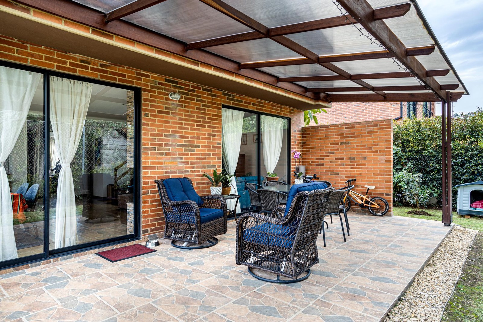 Wicker sofa set with armchairs and a coffee table arranged on a brick patio