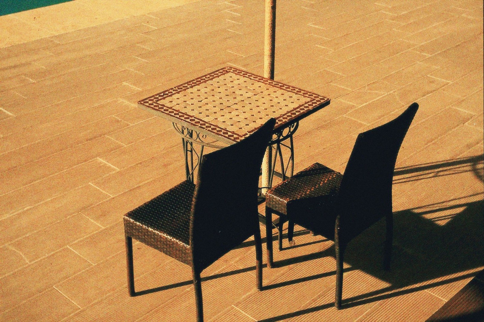 Commercial patio furniture set with a low table and woven seating arranged on a paved terrace