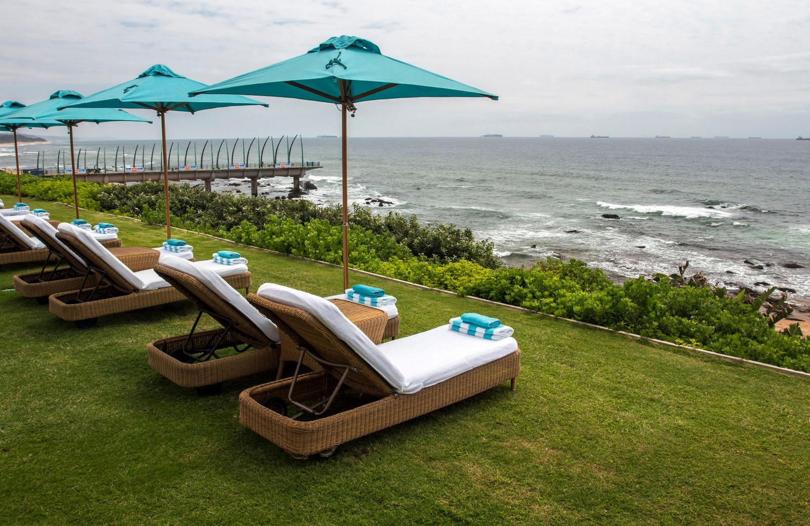 Sun loungers and parasols along a hotel poolside terrace overlooking the sea