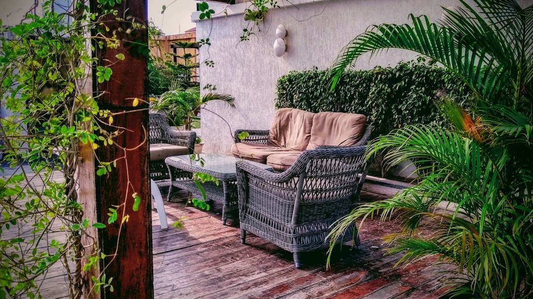 Conjunto de sofás de ratán sintético color gris con cojines beige en una terraza, mobiliario de exterior importado de China