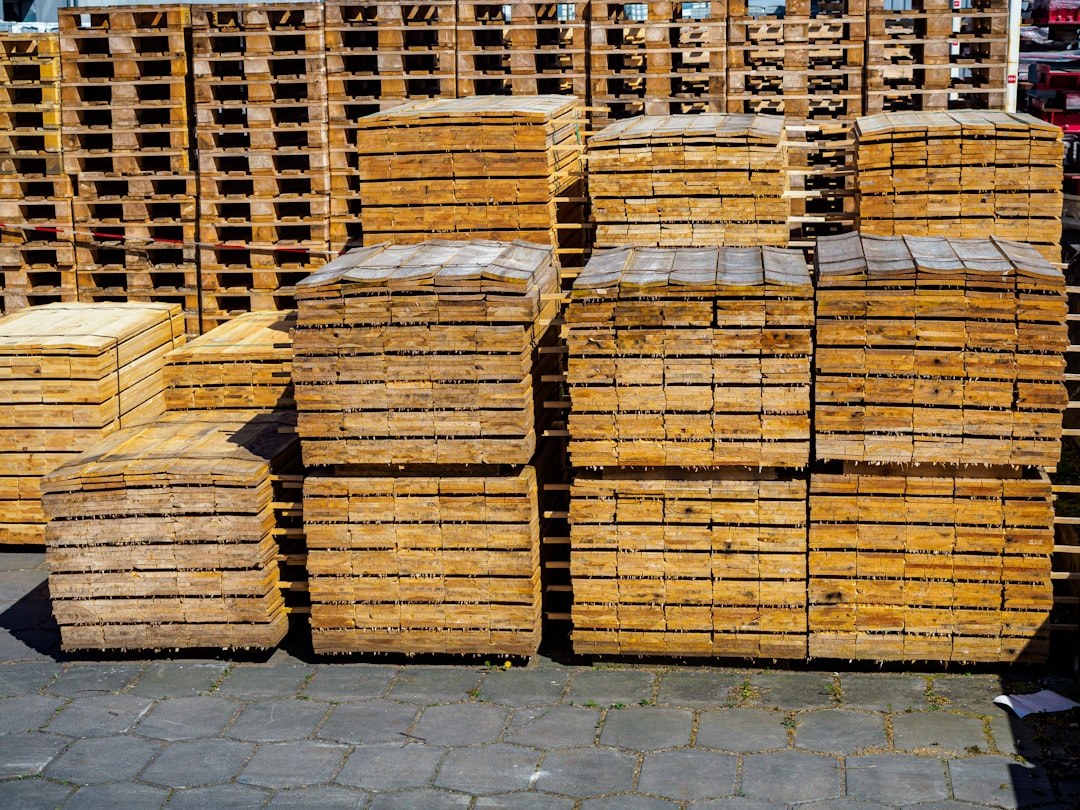 Pilas de palés de madera en un patio industrial, embalaje para la exportación de mobiliario de exterior