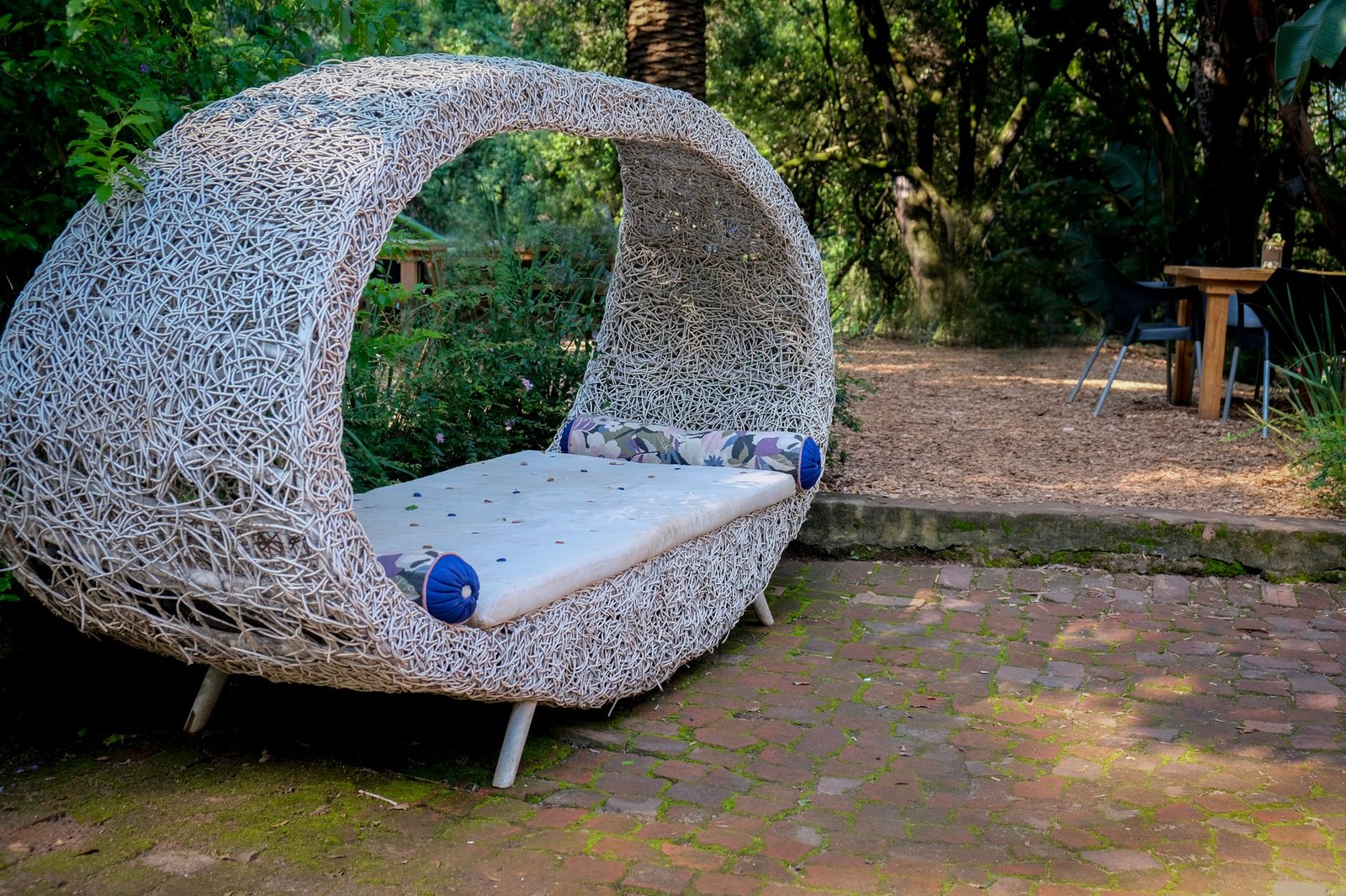 Rattan outdoor daybed with cushions on a hotel pool deck