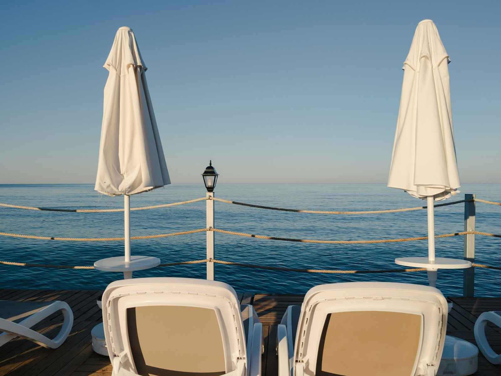 Poolside sunbeds and daybed zone on a seaside deck