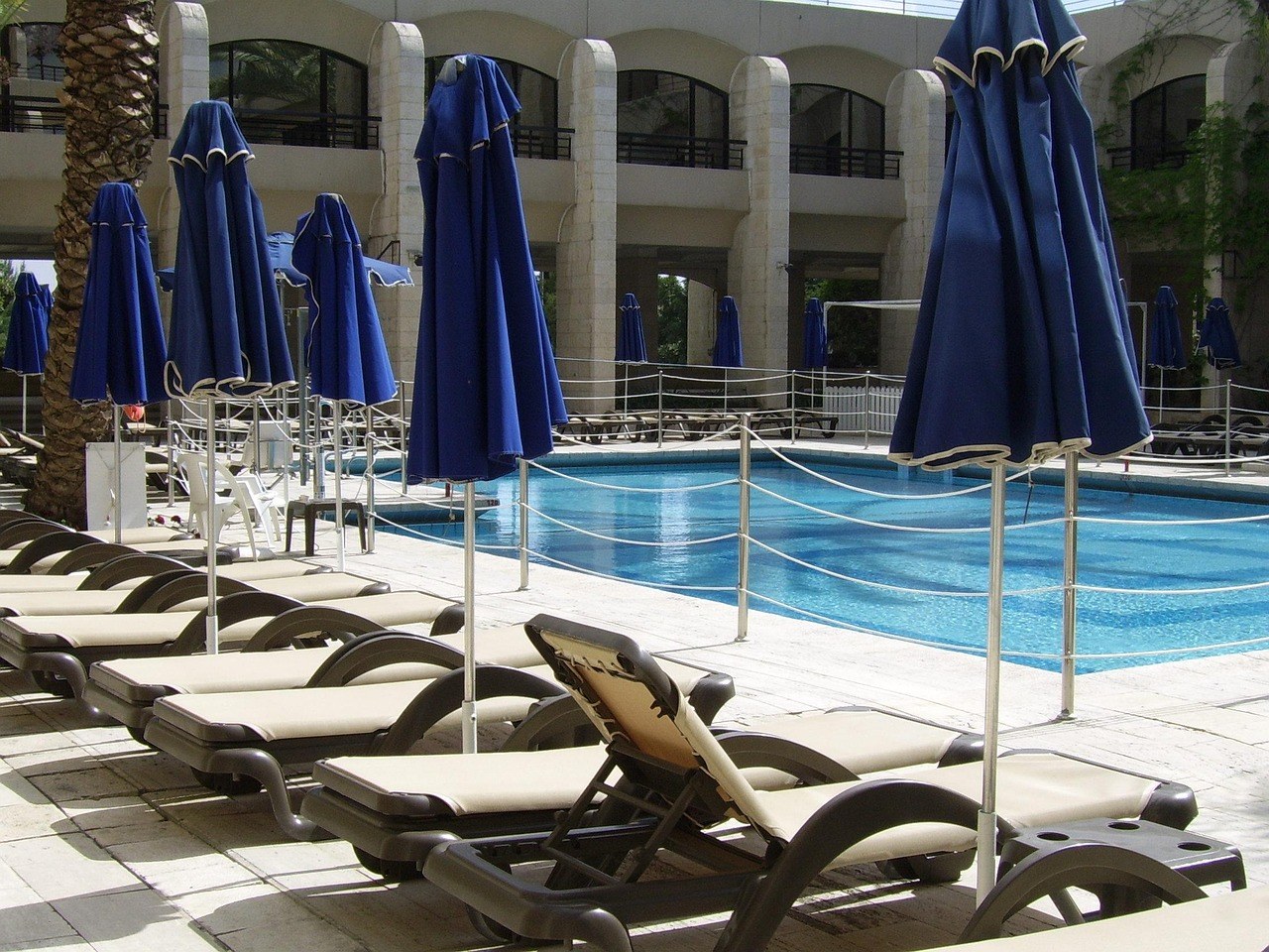Stainless steel pool deck loungers at a resort swimming pool