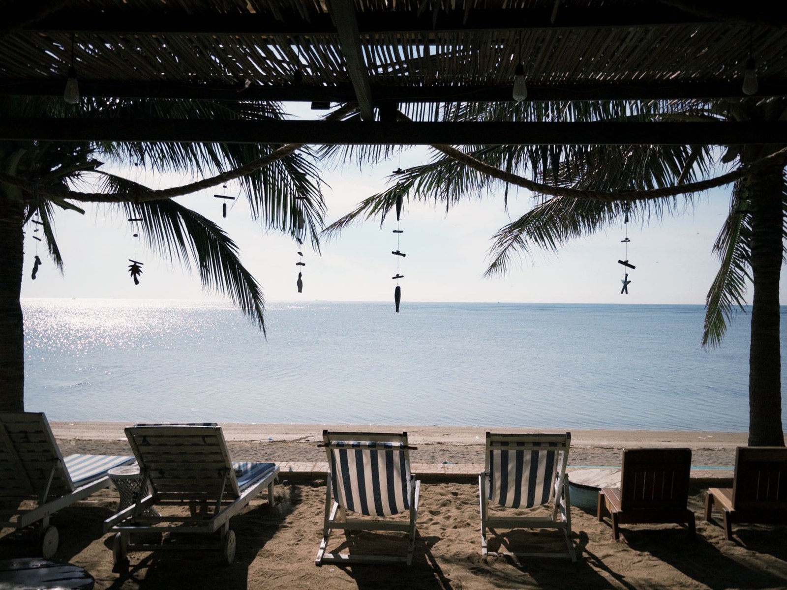 Stainless steel loungers on a beachfront terrace with the sea in the background